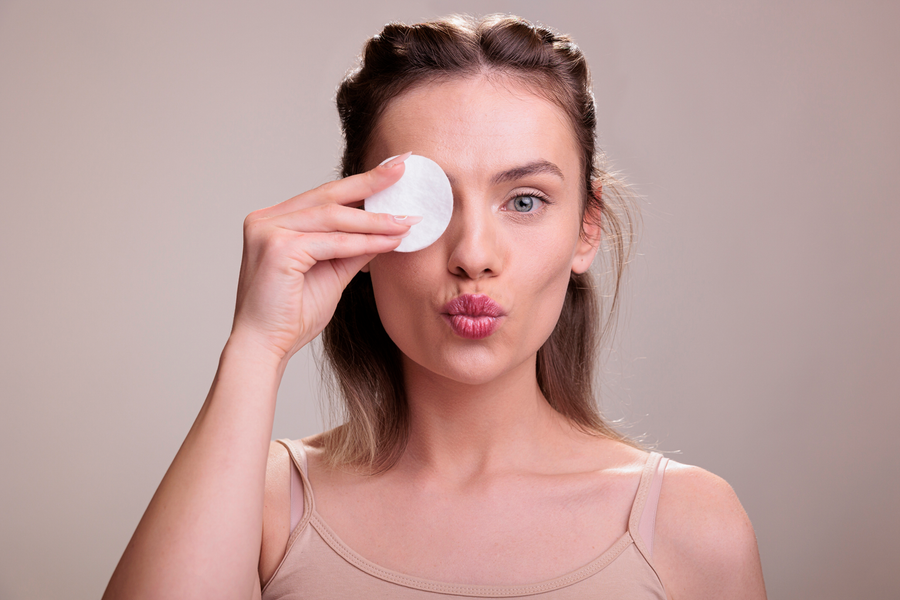Frau entfernt abends sanft ihr Make-up mit einem Wattepad und bereitet ihre Haut auf die anschließende Gesichtspflege vor.