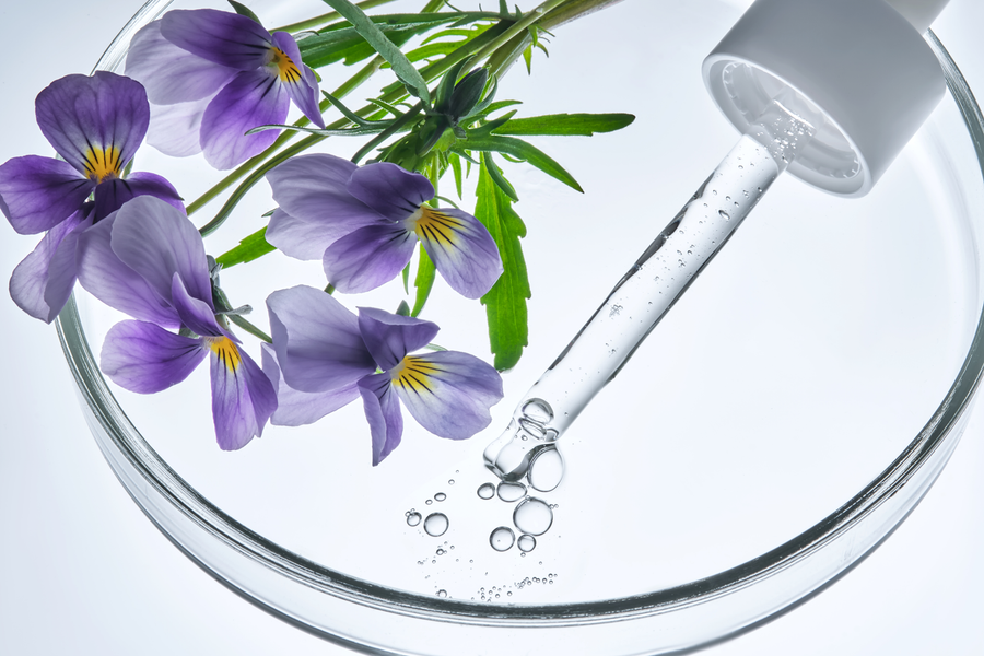 Allantoin als hautpflegender Wirkstoff in einer minimalistischen Labor- und Skincare-Darstellung mit Pipette, Geltextur und kosmetischen Rohstoffen.