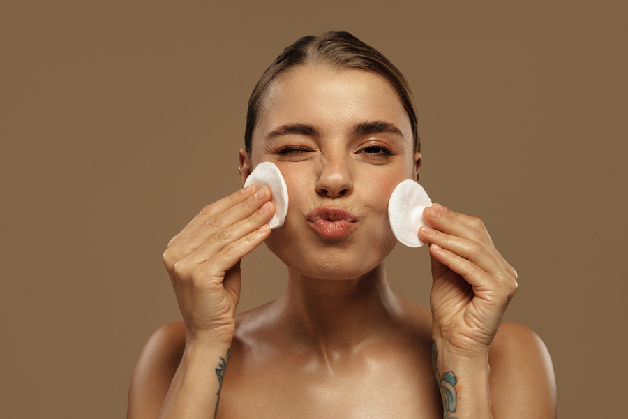Frau reinigt ihr Gesicht mit der Double-Cleansing-Methode als Teil ihrer Hautpflegeroutine.