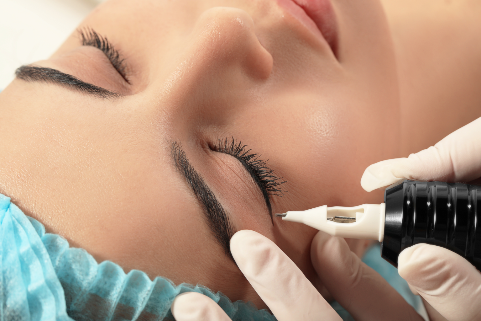 Professionelle Permanent-Make-up-Behandlung der Augenbrauen in einem Kosmetikstudio mit präziser Pigmentierung für natürlich definierte Brauen.